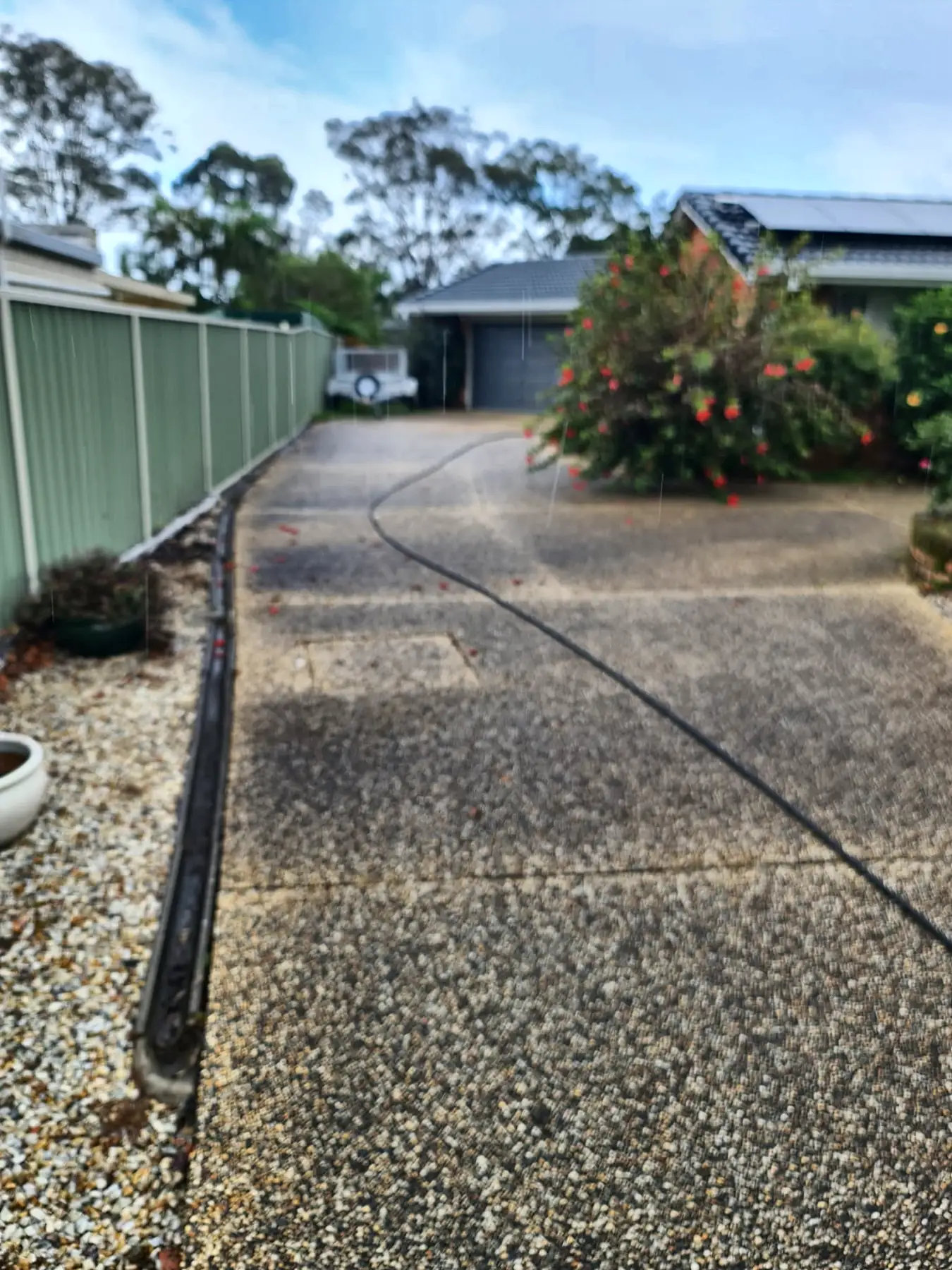 Long aggregate driveway, dark grey and stained before cleaning