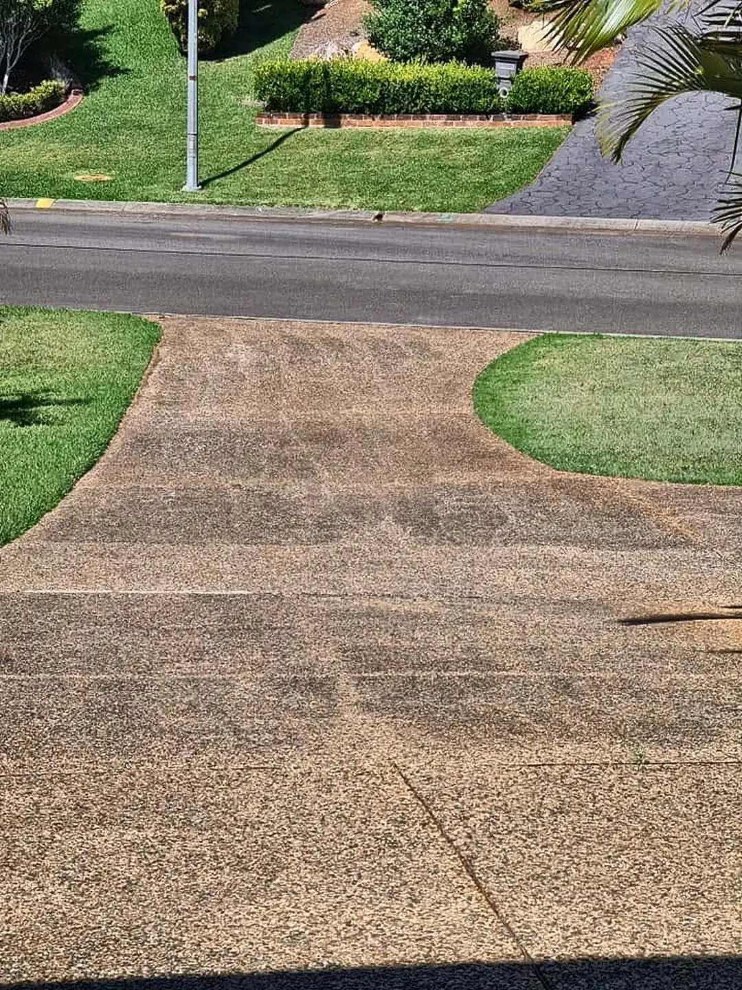 Exposed aggregate driveway stained and dull before cleaning
